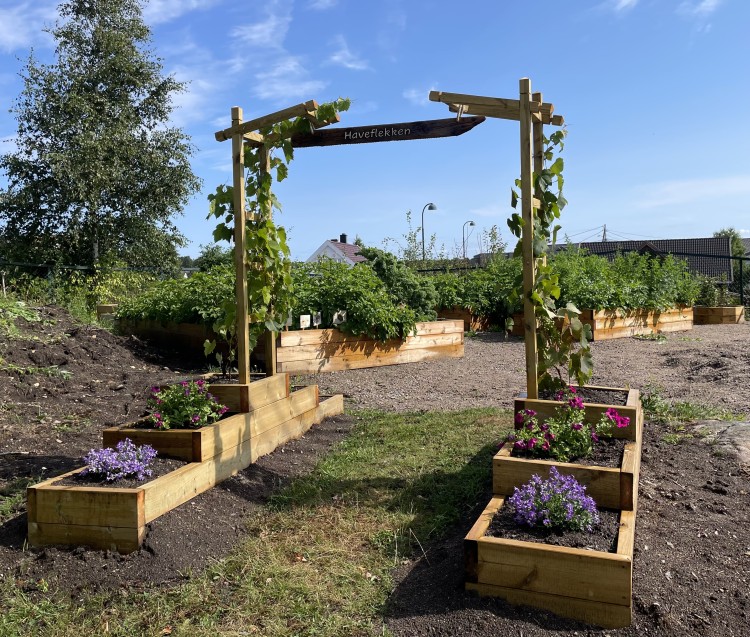 Portal i skolehagen på Flekkerøy skole. På skiltet over portalen står det Haveflekken
